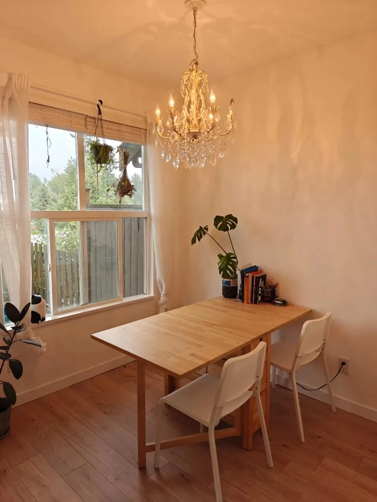 Ms. Karen's tutoring space in South Burnaby: a wooden table, two chairs, books, and plants by a window